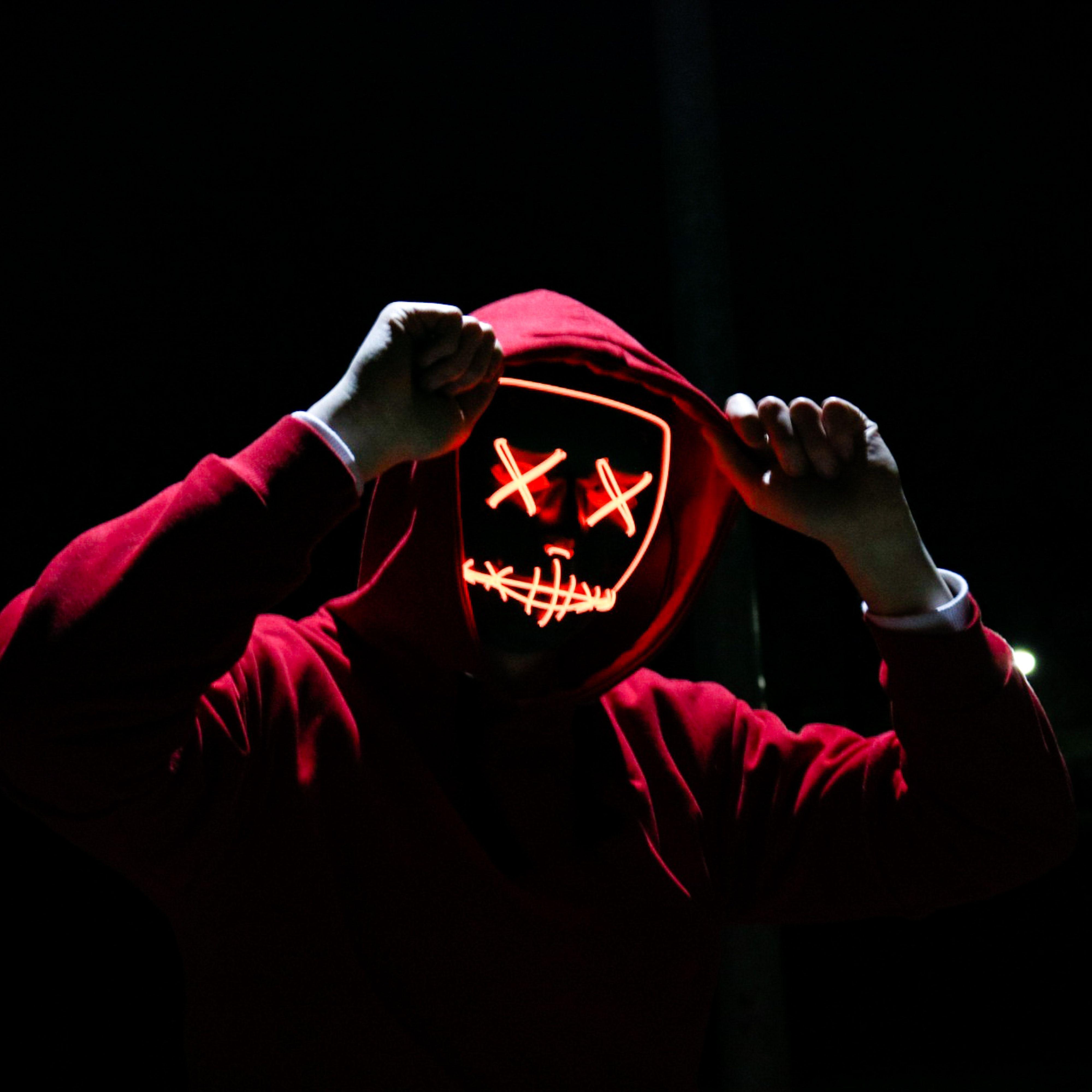 Человек в красной маске. Маска с крестиками вместо глаз. Люди в масках на аву. Неоновая маска анонимус. Маска хакера.