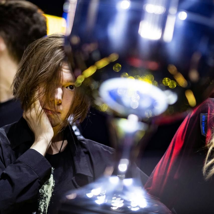 киберспортсмен смотрит на трофей задумчивый взгляд